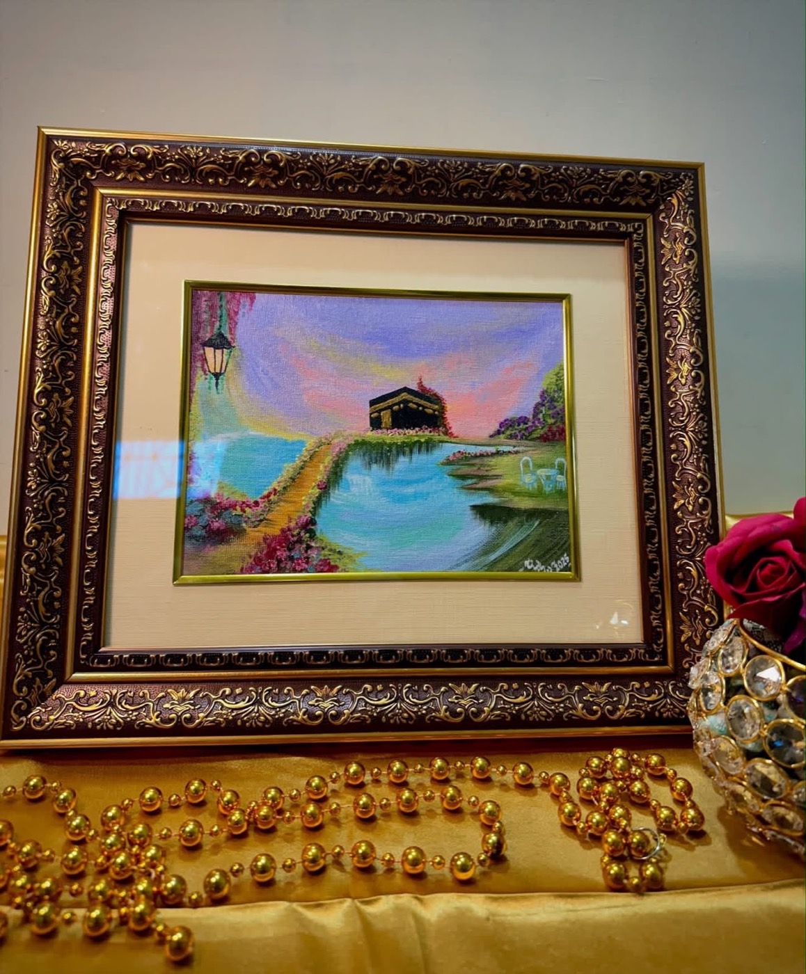 The Garden of Arrival framed in ornate gold, styled with roses, golden beads and a crystal votive