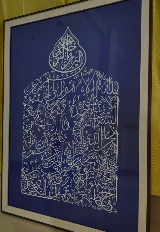 White calligraphy in the shape of a dome on royal blue