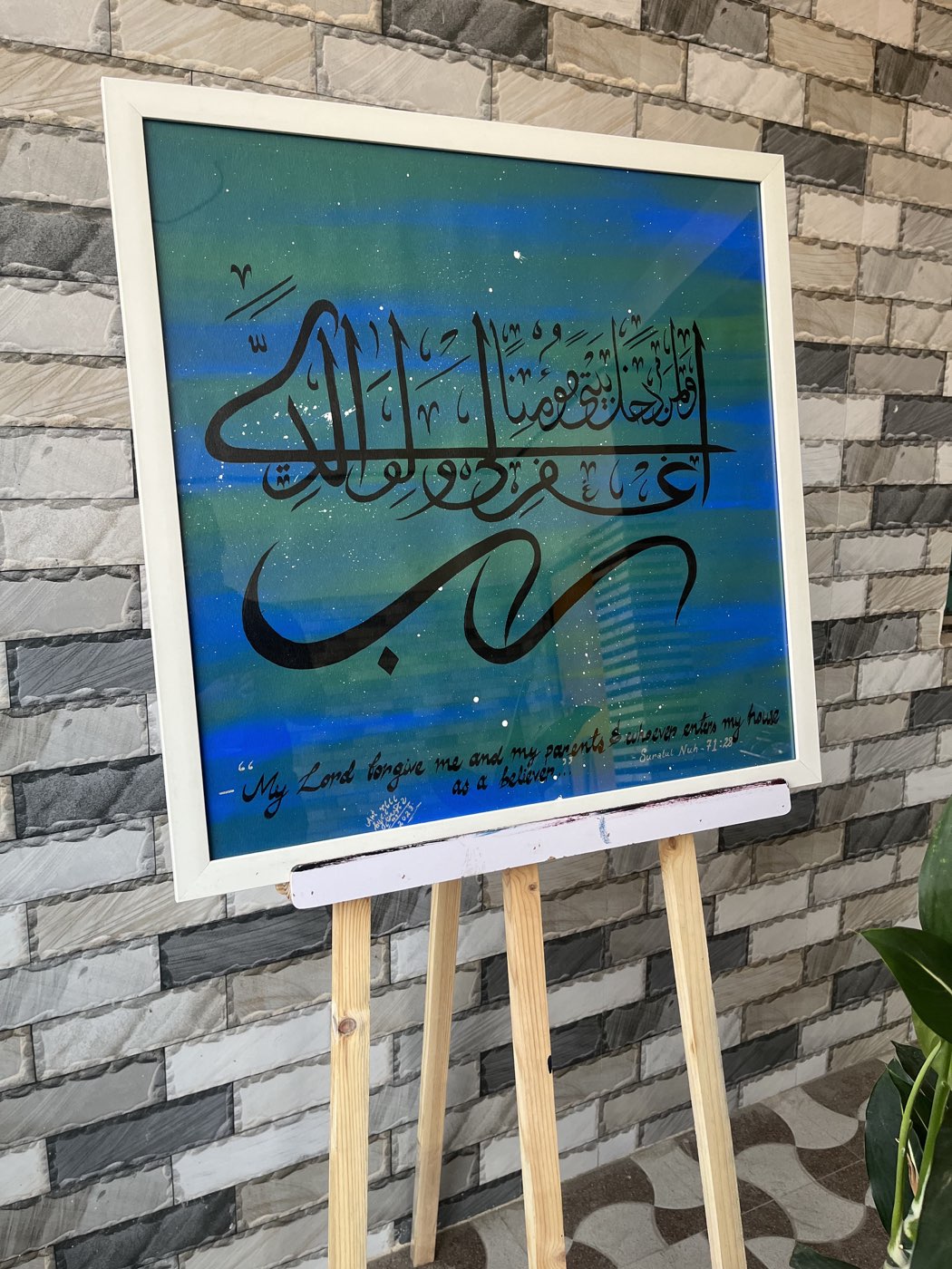Black calligraphy of a prayer for one's parents over an abstract blue-green painted ground