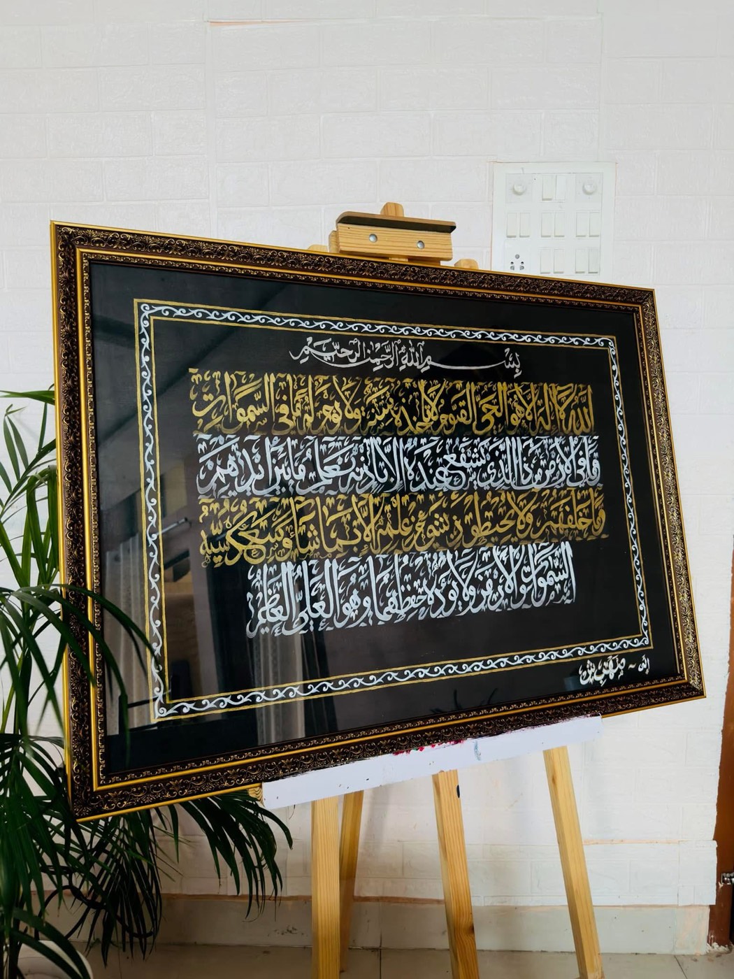 Horizontal bands of gold calligraphy on black inside an ornate illuminated border