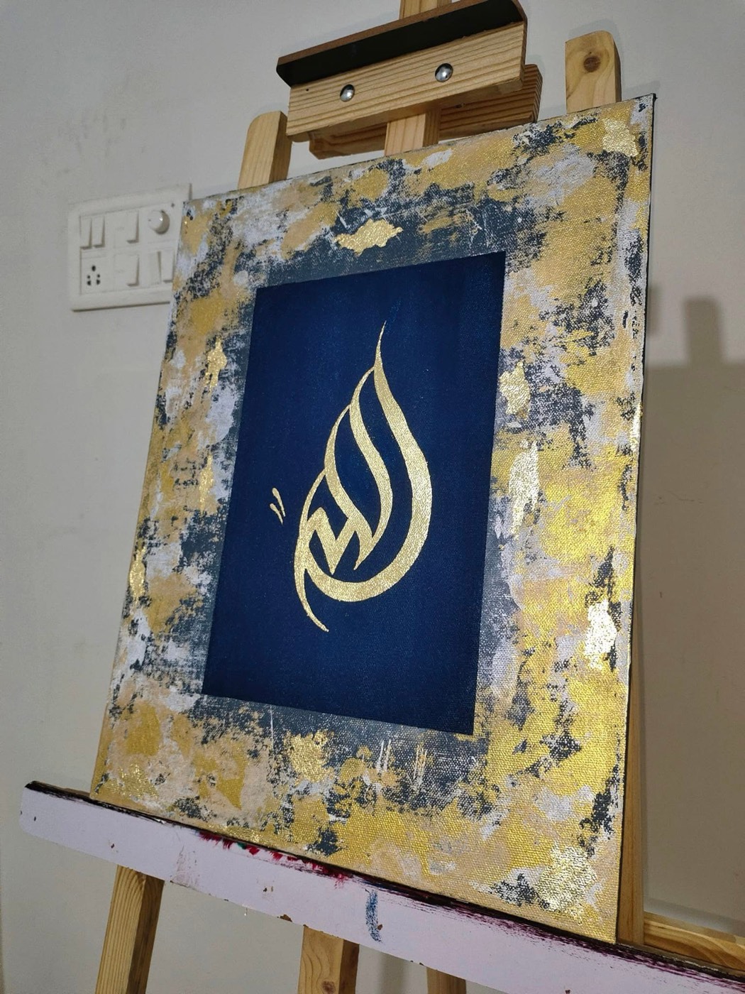 Gold calligraphy on a deep blue central panel surrounded by abstract gold and silver border