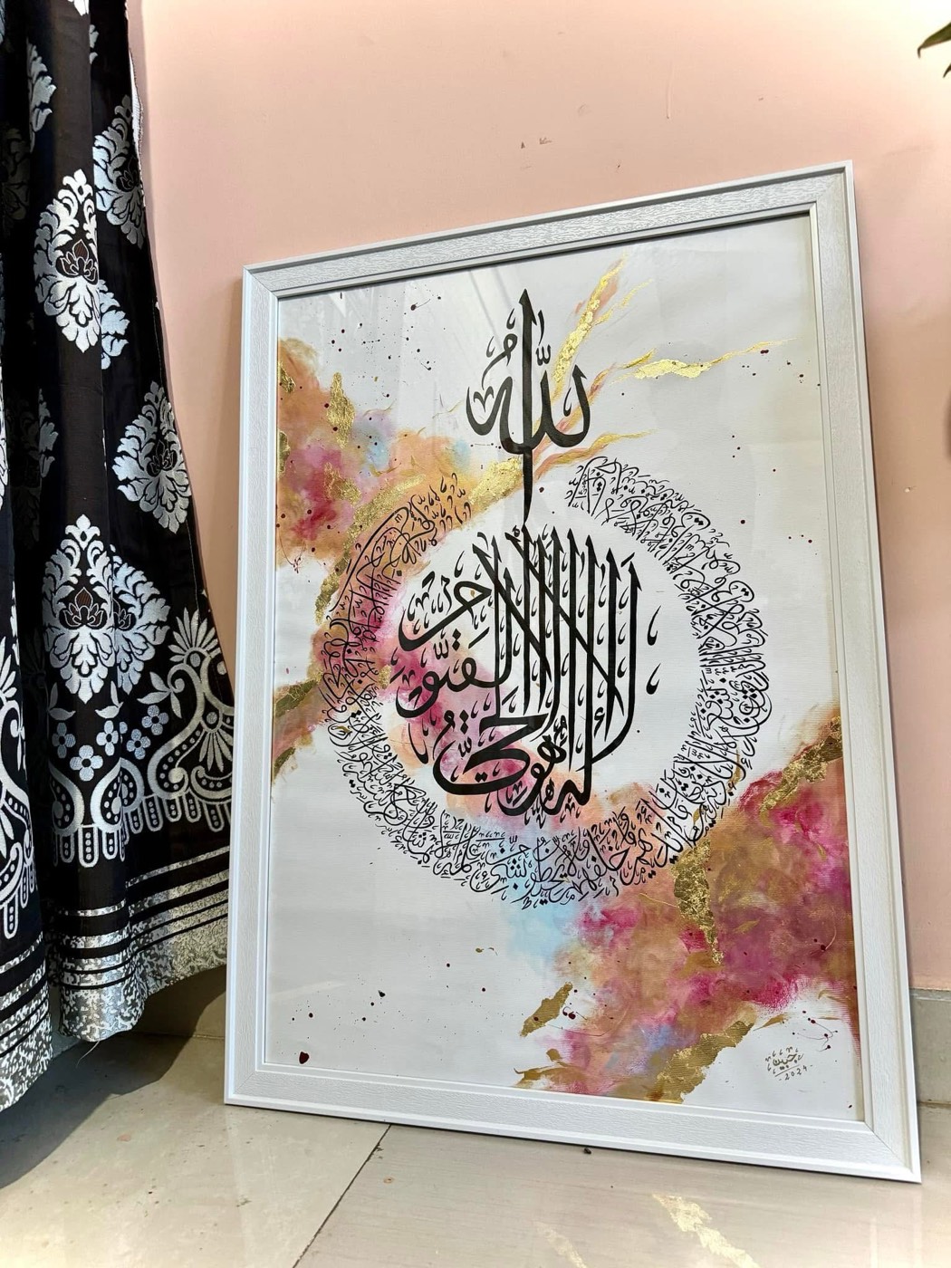 Black calligraphy roundel amid blush pink and gold watercolor clouds, white frame